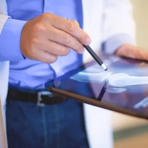 photo of doctor using computer tablet